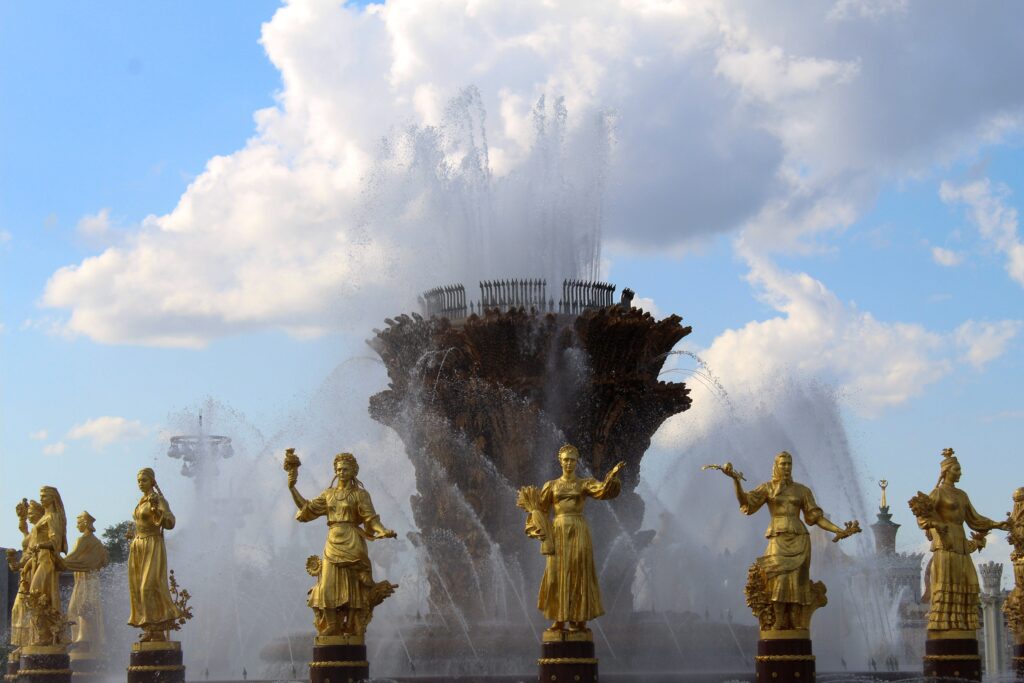 Stunning fountain with golden statues under a blue sky at VDNKh, showcasing artistic craftsmanship.